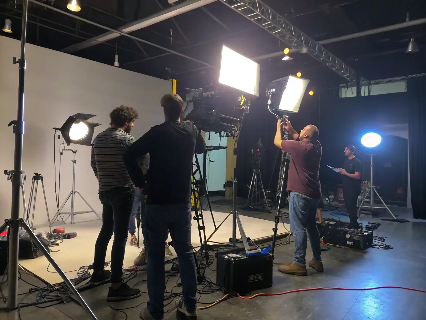 A high-quality image showcasing various professional lighting equipment, such as LED panels, Fresnel lights, and reflectors, arranged in a studio setting. The lighting should be dynamic, highlighting the versatility of the equipment.